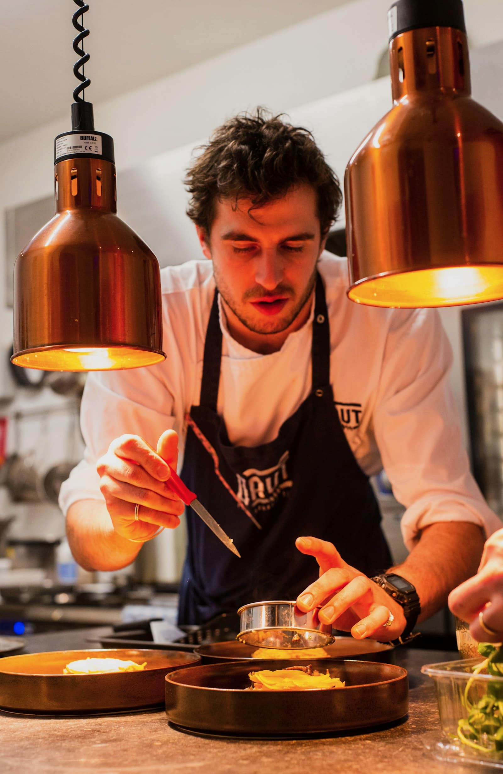 Cocinero trabajando sobre el fuego con leña de mezquite